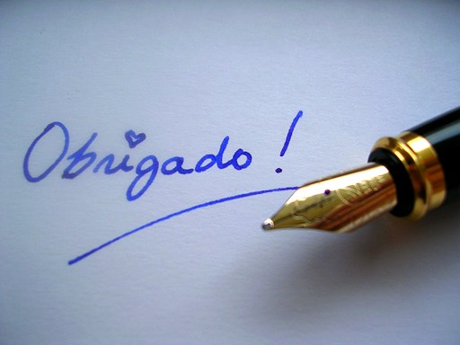 Close-up of a fountain pen nib beside handwritten ink